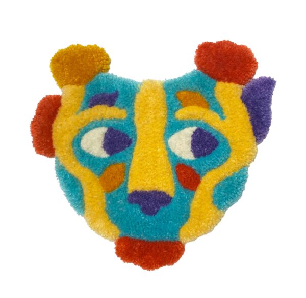 tufted forest creature mask in blue, yellow, red, purple, and orange